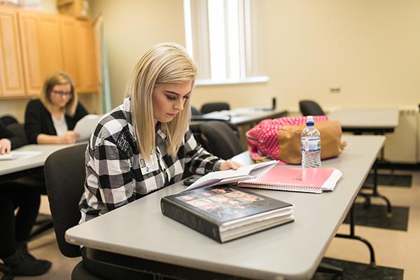 A cosmetology student studies class materials