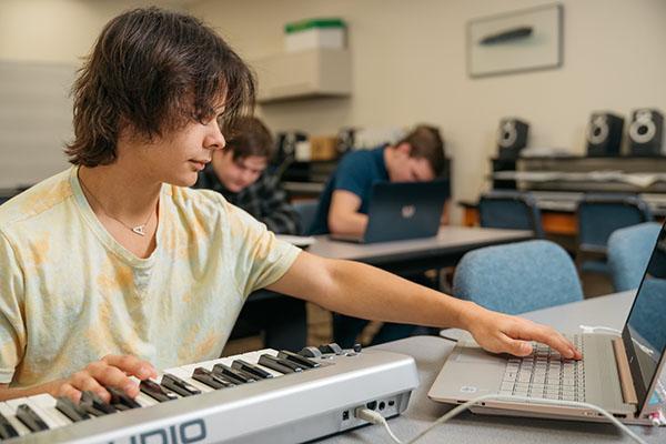 A music student works at a keyboard