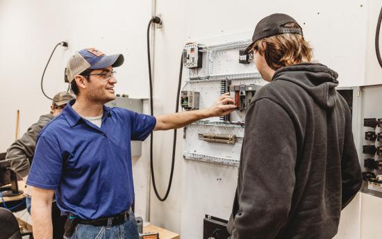 An electrical student looking at a breaker box